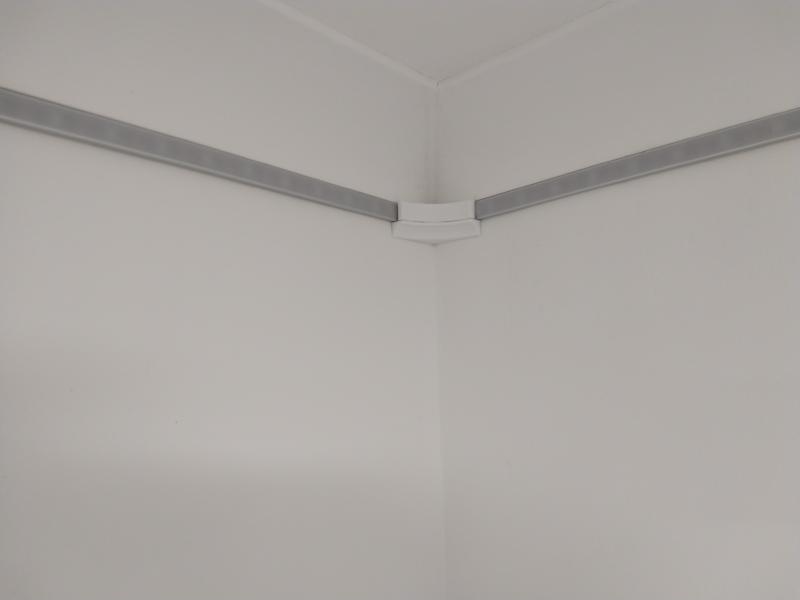 A corner under the ceiling; LED strip in aluminium profile with a diffusing cover comes in from both ends. The corner itself is covered by a white 3D printed piece.