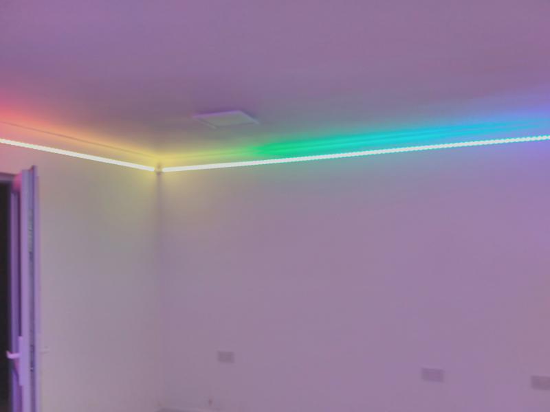 View of a corner with LED strip lit up, this time showing a smooth rainbow gradient
