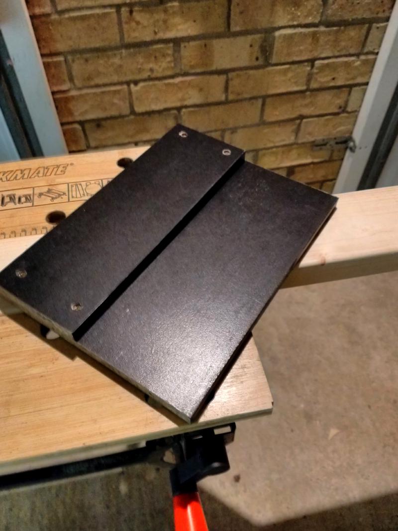Home-made jig made of two straight planks of wood screwed together. The bottom one is wider by some 10-15 centimetres, and the difference between them forms a guide line to push the circular saw up against