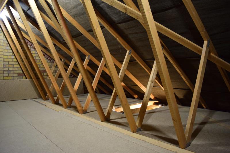View from the centre-ish of the loft space, looking toward where there's a hole in the floor and the ladder peeks out.