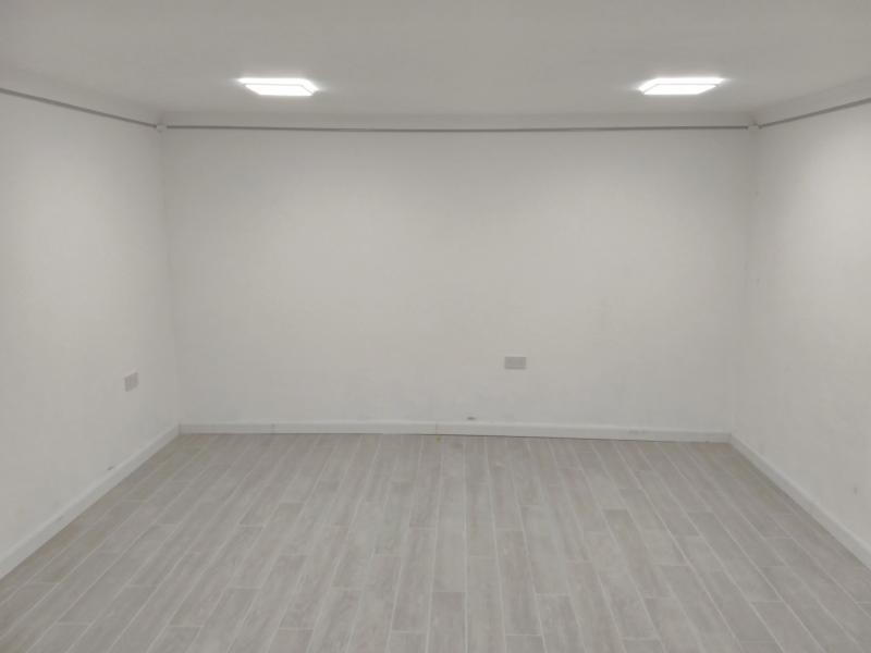 Wide view of the empty room, showing skirting board installed all around.