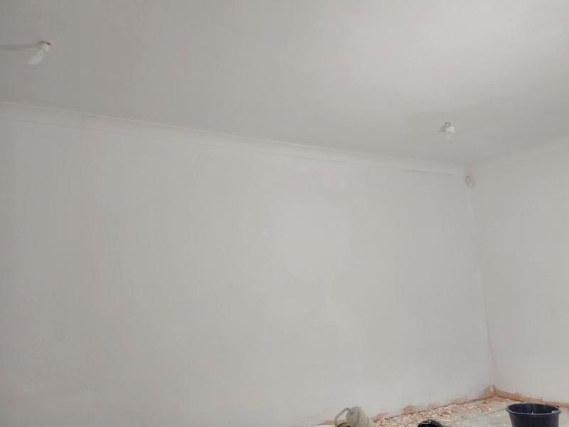 Picture of the same wall from another angle, now an even white. The old peels are still on the floor near it.