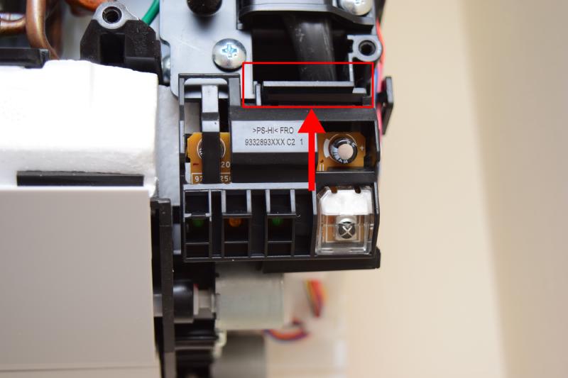 Closeup of the module containing the infrared sensor. In the bottom right of the module is a clear plastic case with a an infrared sensor behind it. To its left are LEDs is segregated plastic chambers, preventing light leaks. On the top, a latch is marked with a rectangle and arrow pointing up.