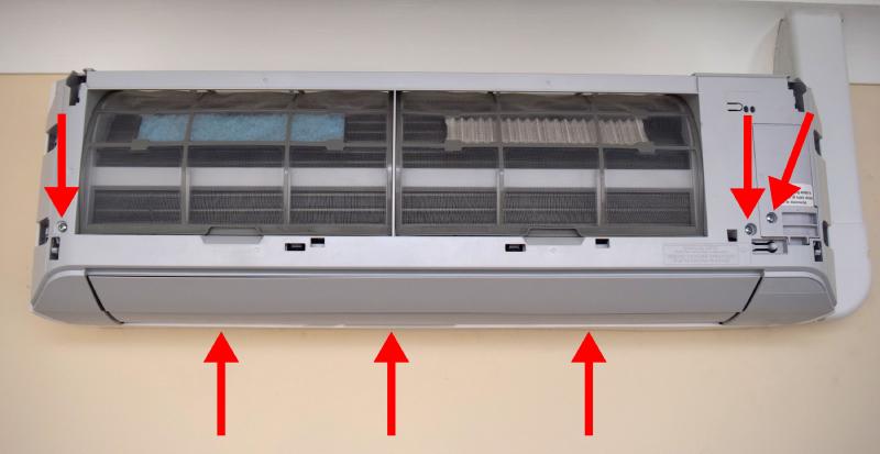 AC unit without the top cover. Arrows point at screws to be removed, described below.