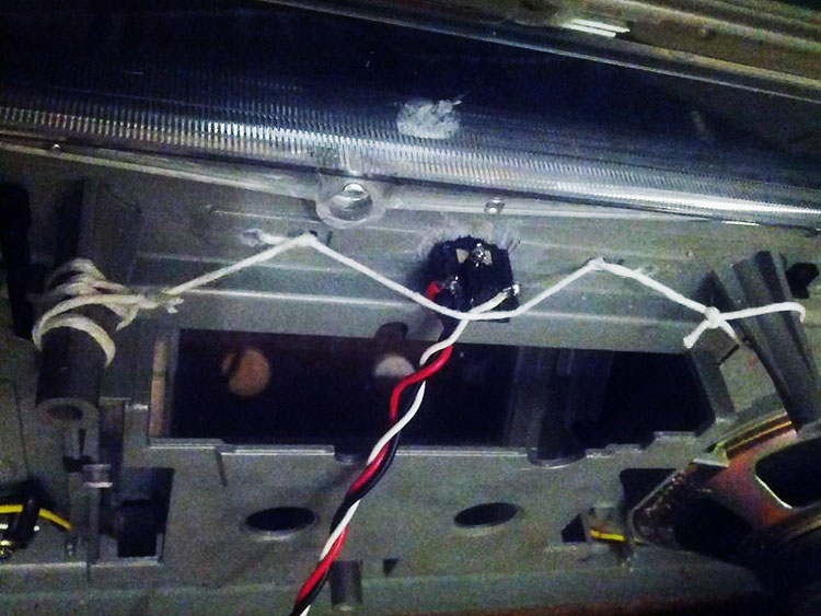 Photo showing the socket inserted into the front-panel, held in place by taut string, knotted badly around what was available